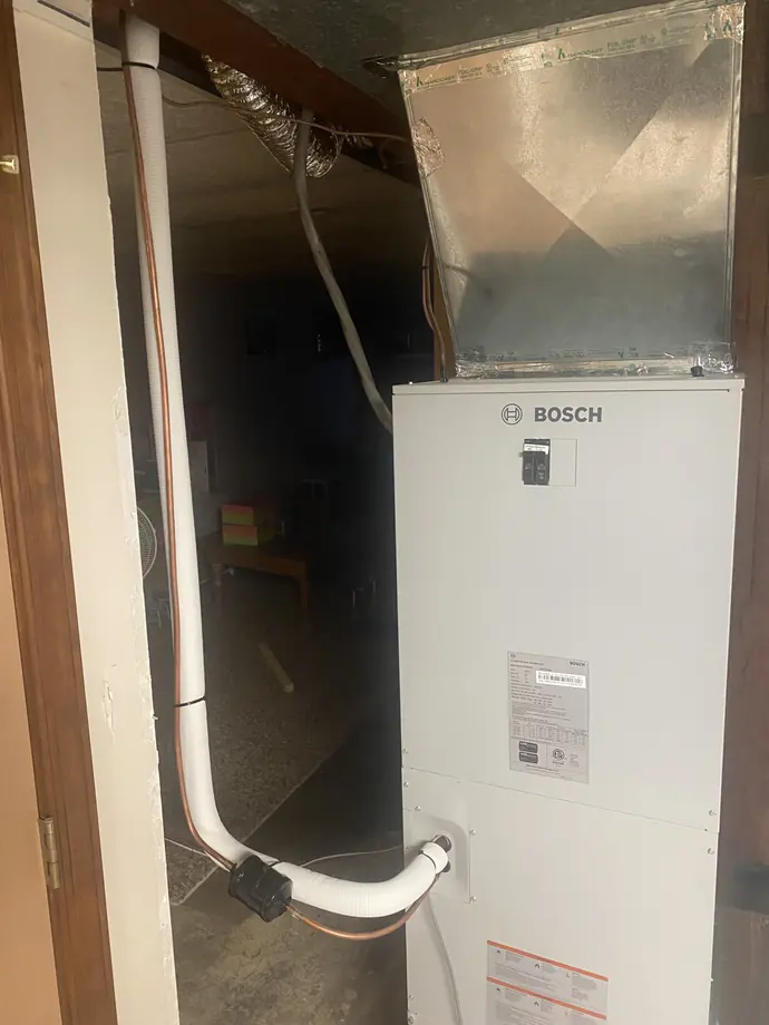 White Bosch indoor air handling unit and adjacent metal supply duct