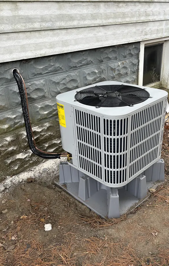 White outdoor Bosch unit next to textured masonry foundation and light siding