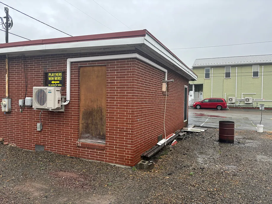 Small brick business building with wall-mounted outdoor ductless HVAC system