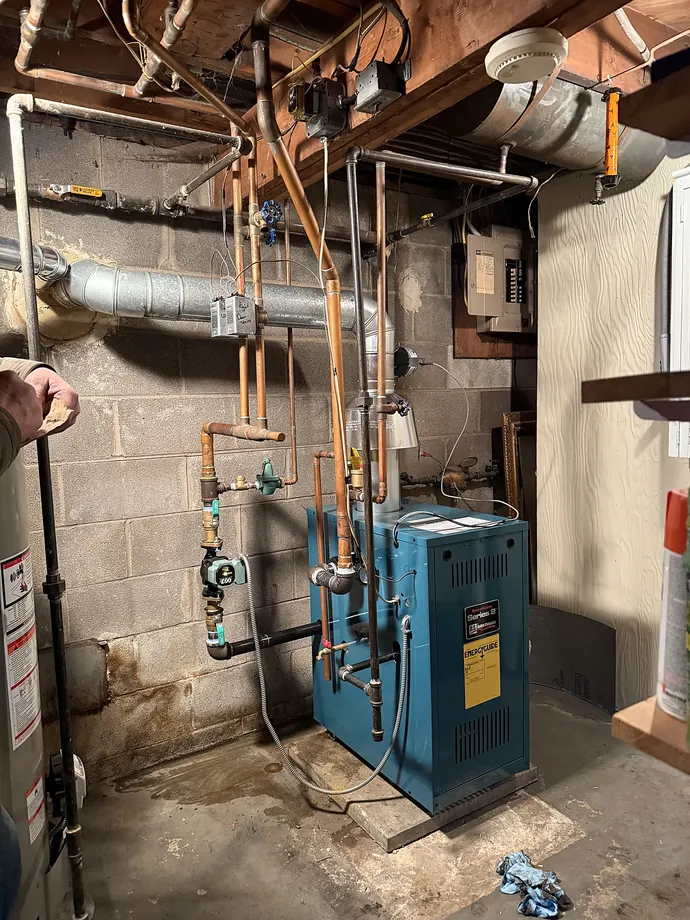 Boiler installation with copper piping in a residential mechanical room
