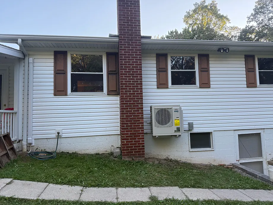 Residential facade showing white wall-mounted outdoor mini-split unit
