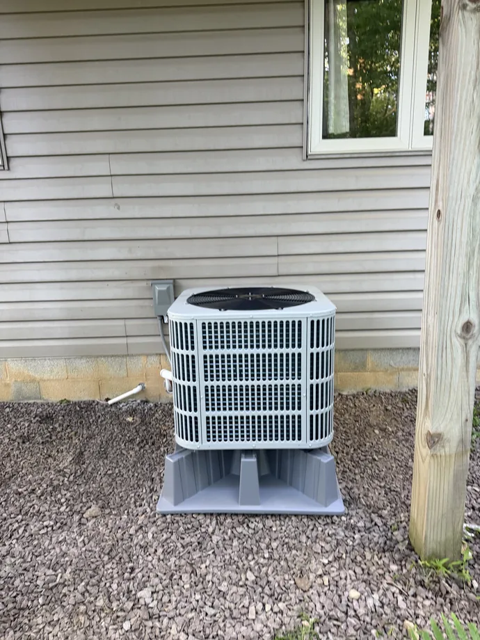 Finished white Bosch outdoor condenser against light gray exterior siding