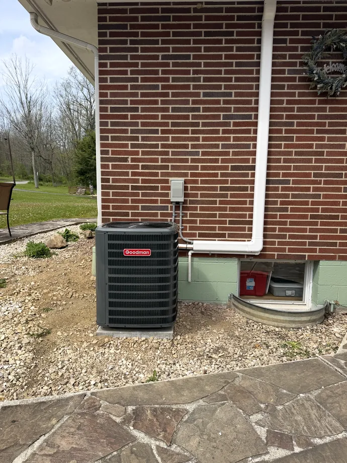 Outdoor system beside red brick home with finished white exterior line routing